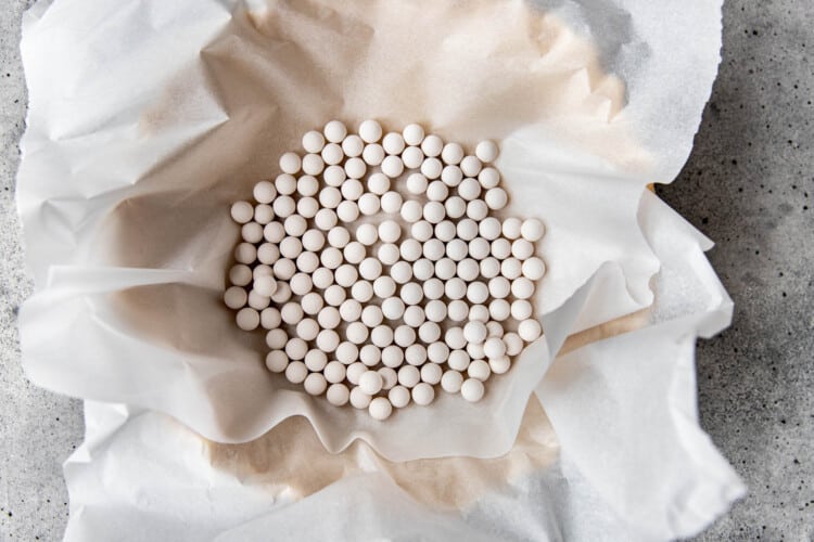 pie pan with parchment paper and white pie weights