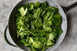 saute pan with spinach leaves