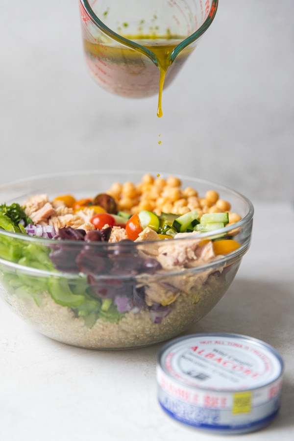 dressing being poured on a Mediterranean Tuna Salad 