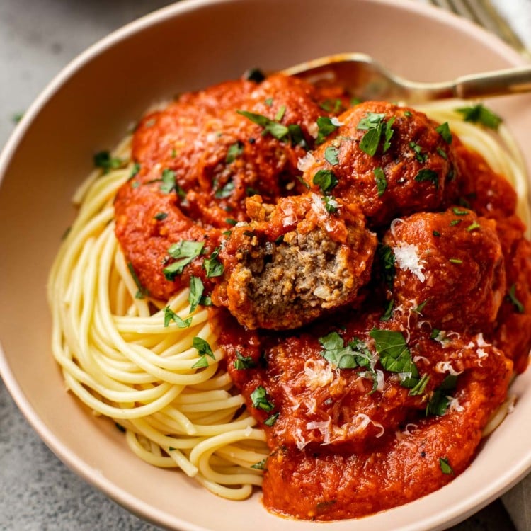 bowl with spaghetti noodles, marinara sauce and meatballs