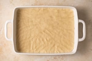 apple pie bars batter in a baking dish