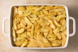 baking dish with apple pie bars sliced apple layer