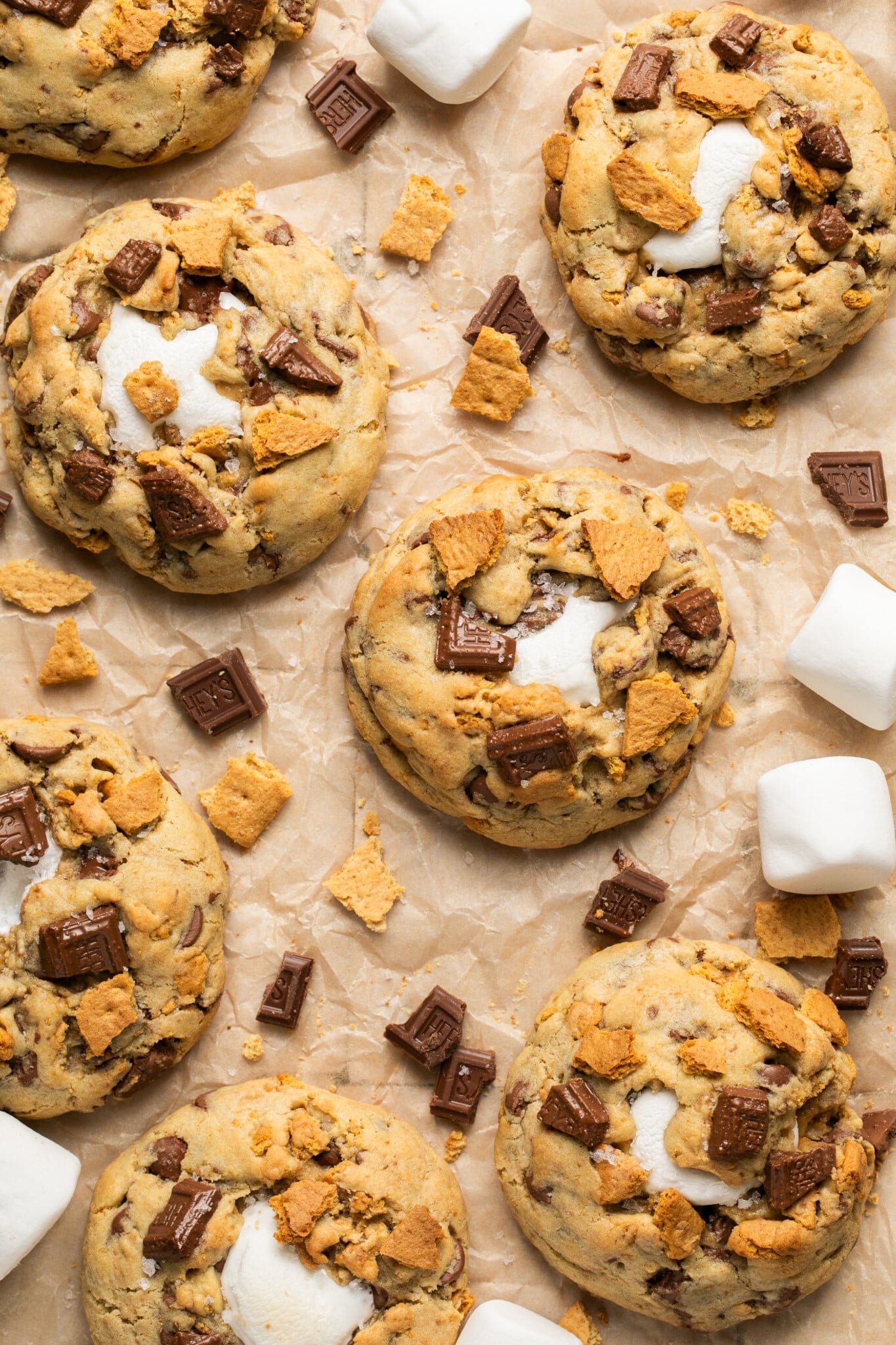 smores cookies on parchment paper decorated with hersheys chocolate and graham crackers. 