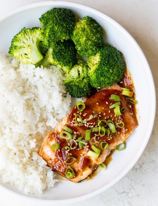 teriyaki glazed salmon in a white bowl with rice and broccoli
