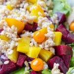 beets and barley on top of lettuce in a bowl