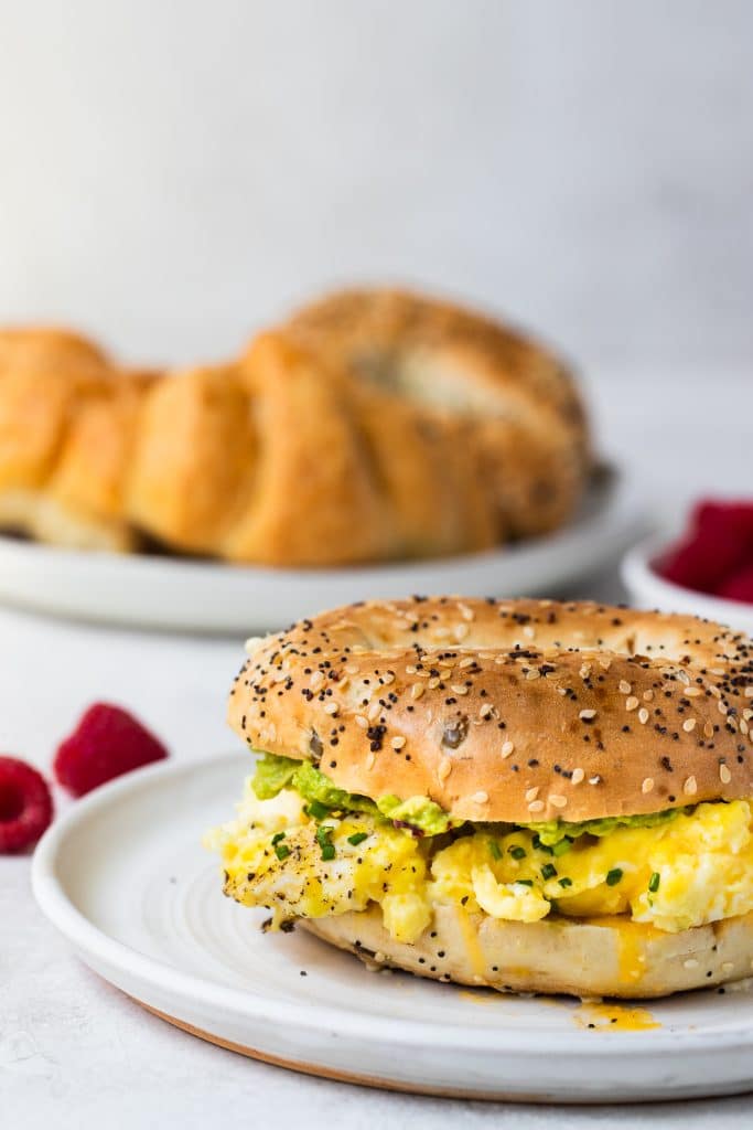 creamy scrambled eggs on a bagel on a white plate