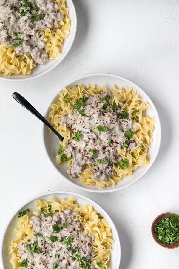 Ground Turkey Stroganoff in white bowls with egg noodles