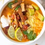 taco soup in a white bowl with toppings on top