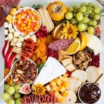 fruits, meats and cheese on a cutting board