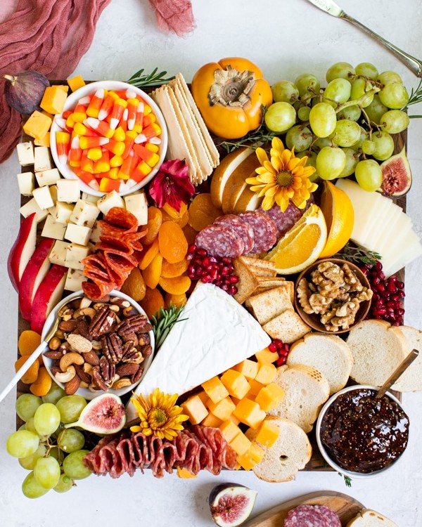 fruits, meats and cheese on a cutting board