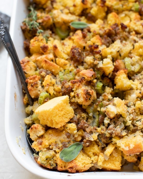 cornbread stuffing made with sausage and herbs in a white casserole dish
