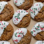 molasses cookies covered in sanding sugar on parchment paper dipped in white chocolate