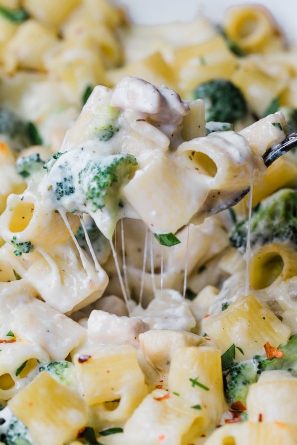 a spoon serving chicken alfredo pasta