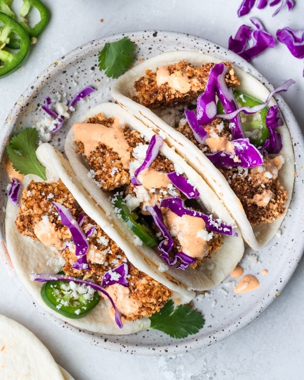 mahi mahi tacos on a white speckled plate