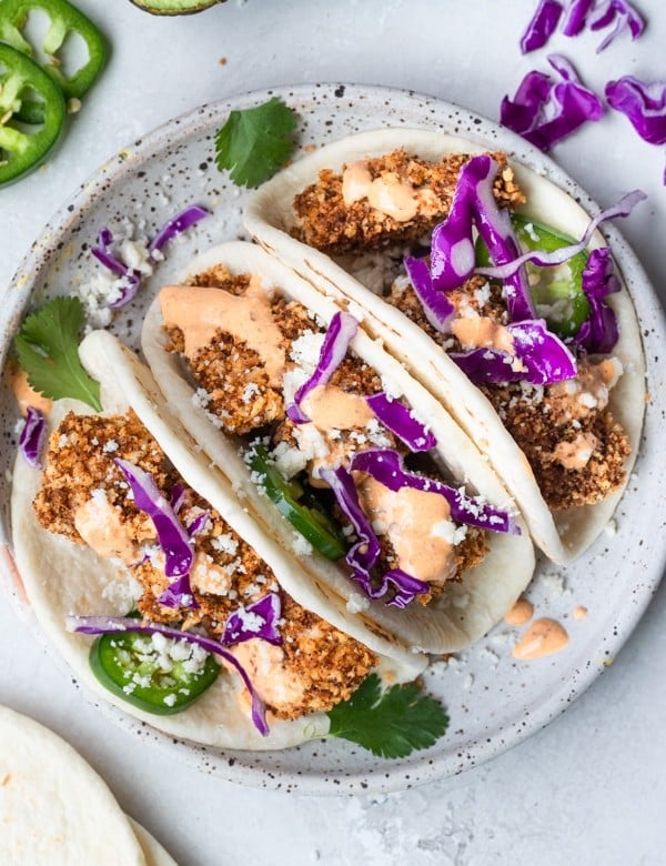 mahi mahi tacos on a white speckled plate
