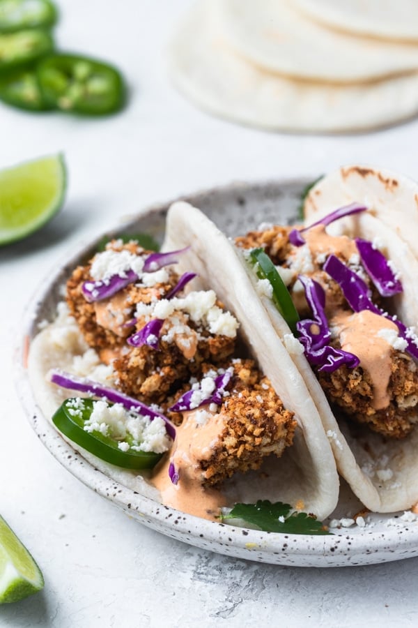 mahi mahi tacos on a white speckled plate