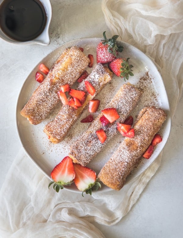 french toast on a white plate with strawberries