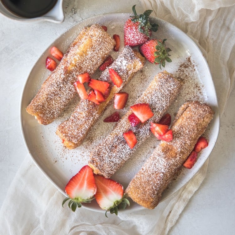 french toast on a white plate with strawberries