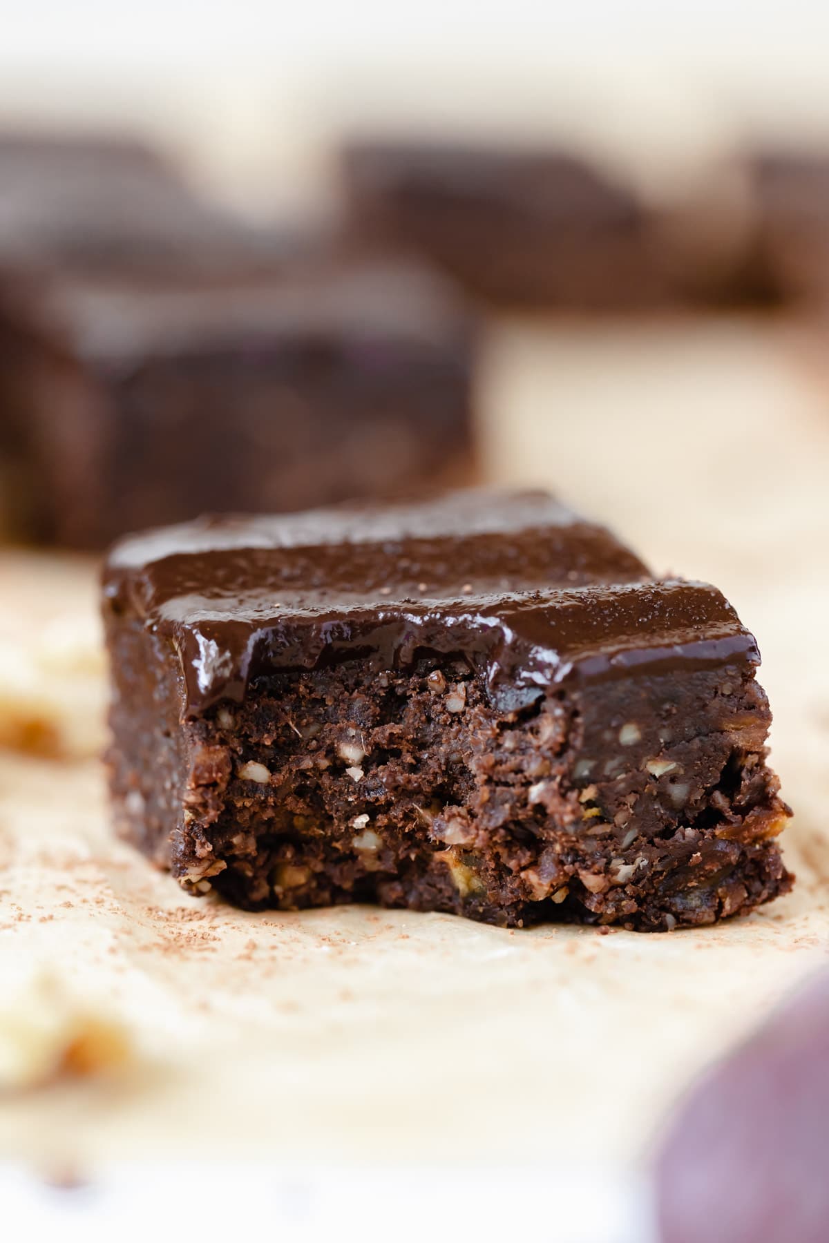 a bite taken out of a brownie on parchment paper