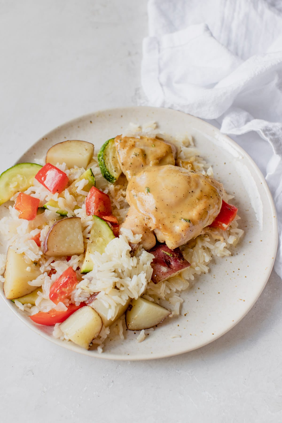 chicken with veggies and rice on a white plate