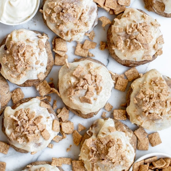cinnamon toast crunch cookies on a marble slab with cream cheese frosting on top