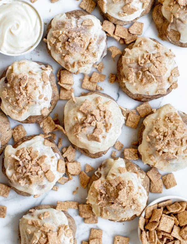 cinnamon toast crunch cookies on a marble slab with cream cheese frosting on top