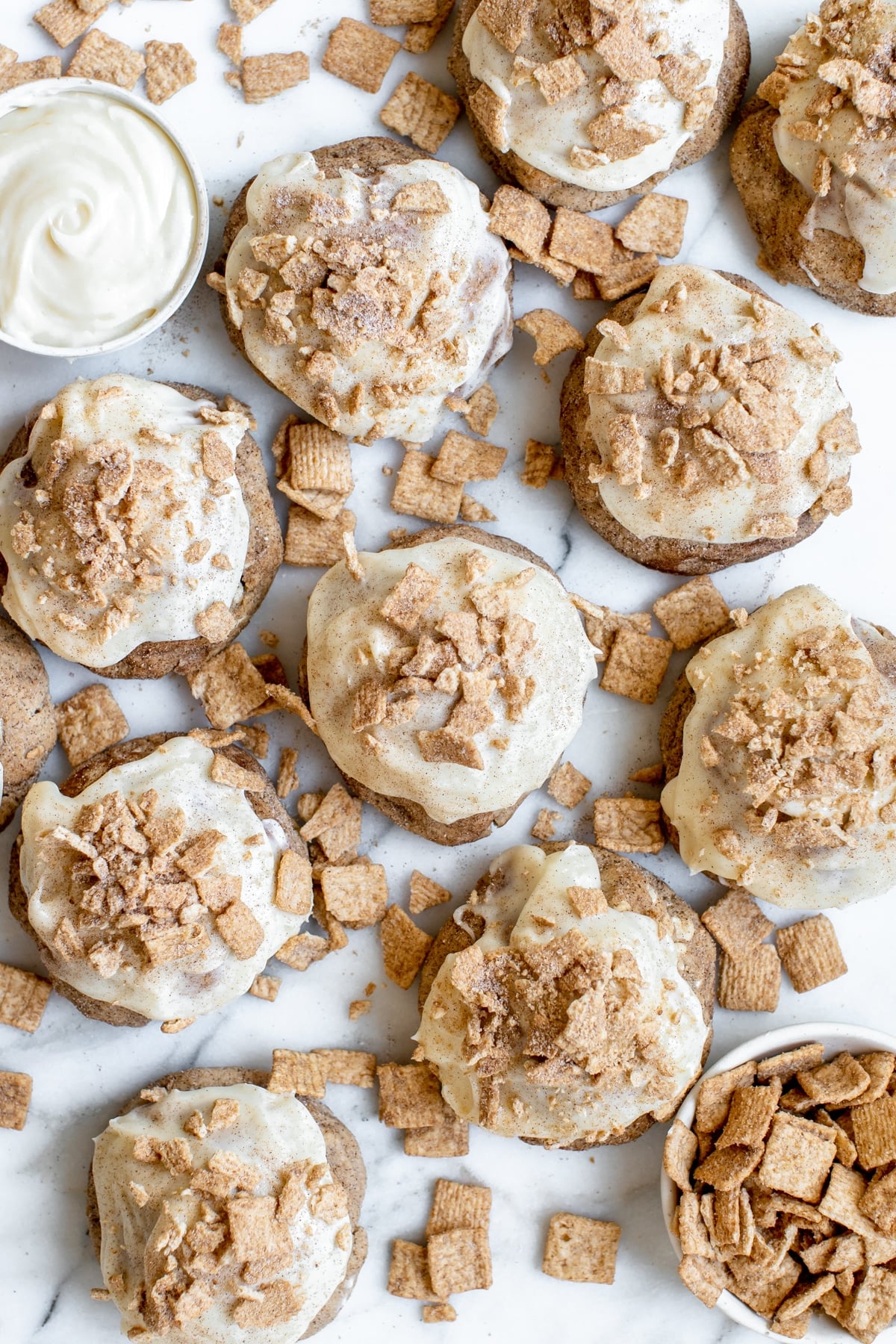 cinnamon toast crunch cookies on a marble slab with cream cheese frosting on top