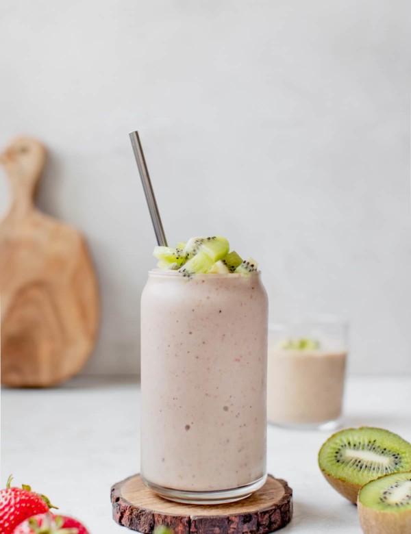 smoothie in a glass topped with diced kiwi