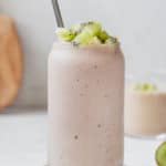 smoothie in a glass topped with diced kiwi