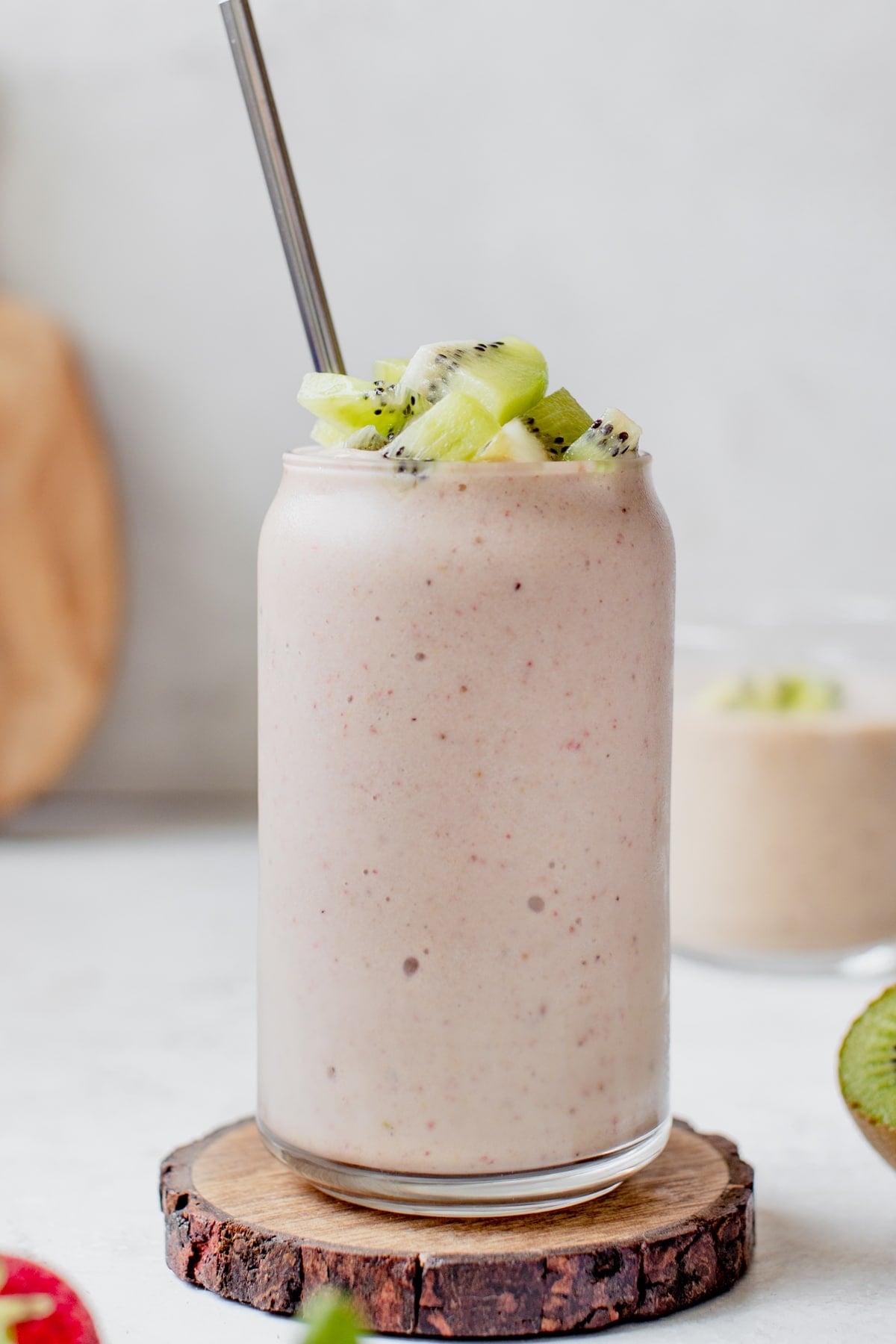 smoothie in a glass topped with diced kiwi