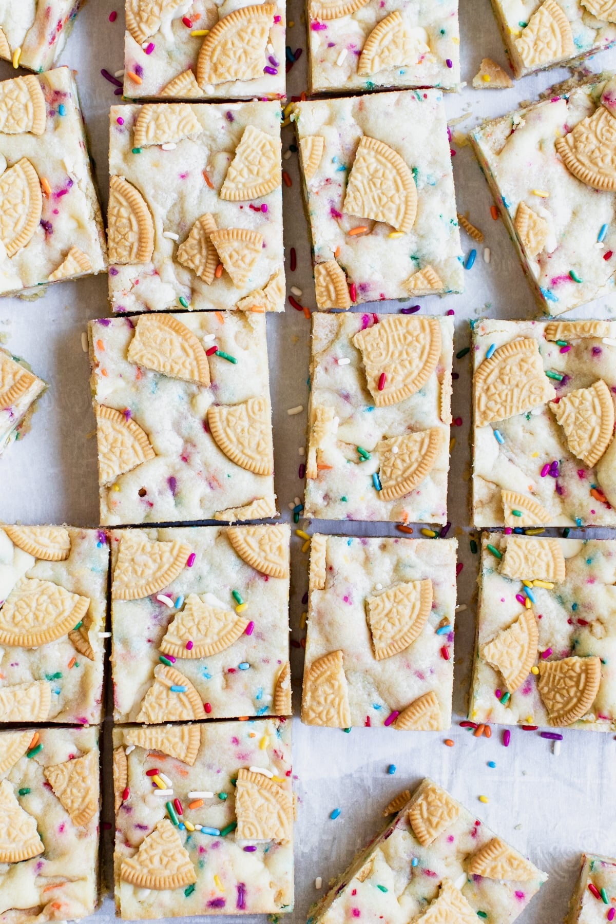 cookie bars on parchment paper with sprinkles and golden oreos 