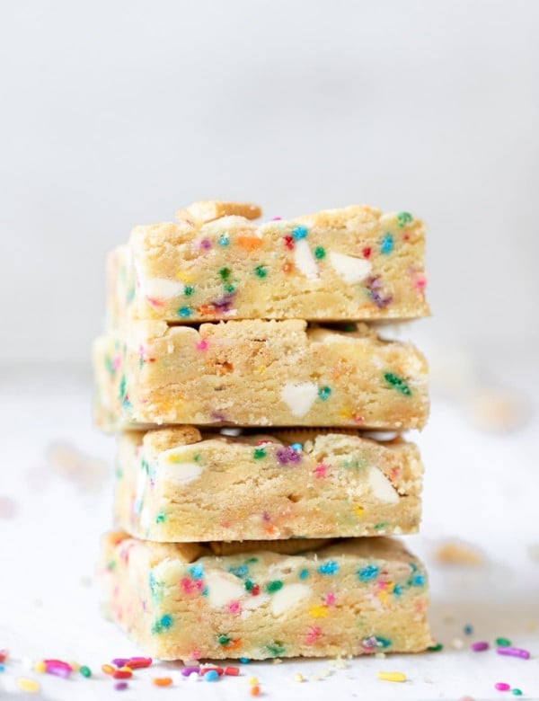 a close up photo of funfetti cookie bars stacked on top of each other