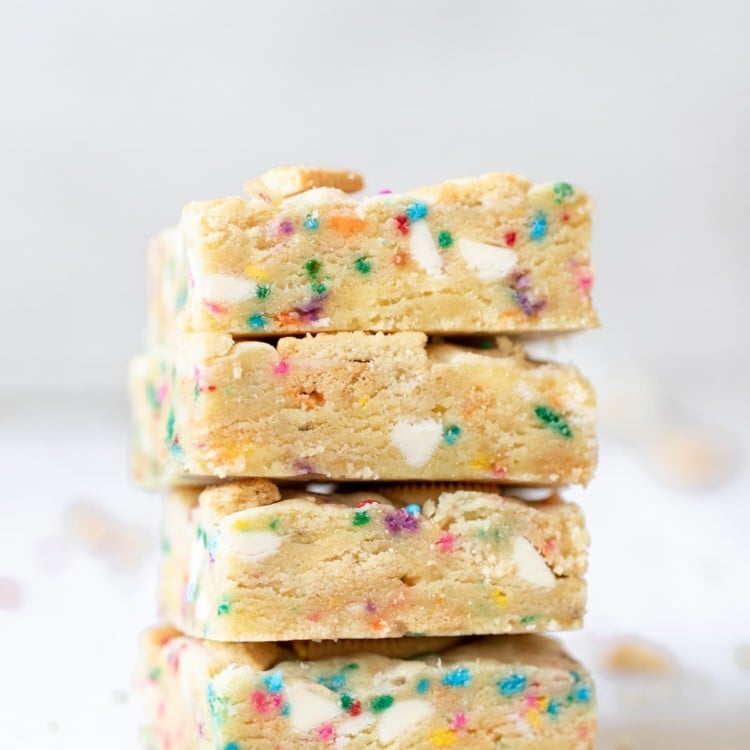a close up photo of funfetti cookie bars stacked on top of each other