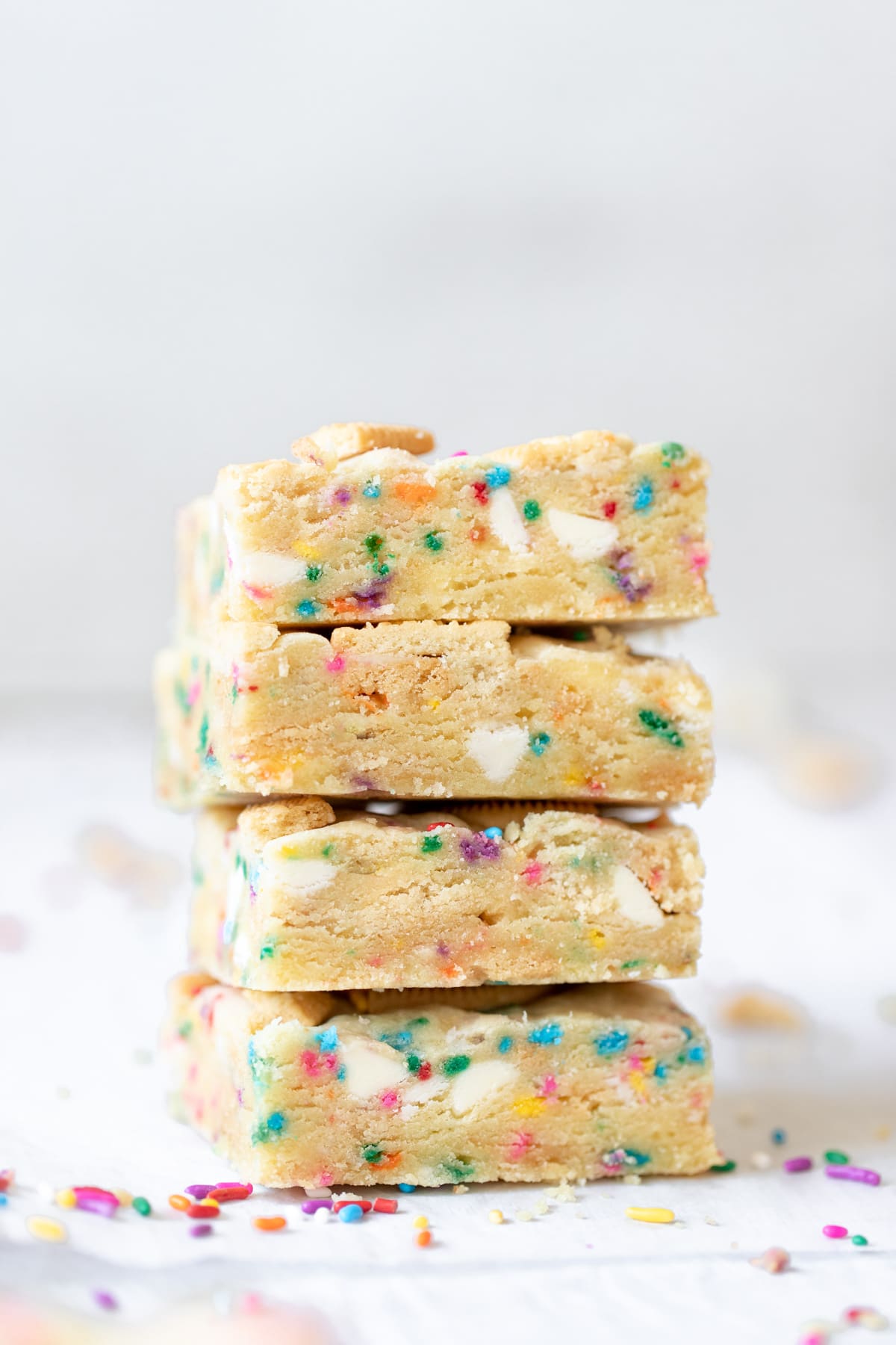 a close up photo of funfetti cookie bars stacked on top of each other