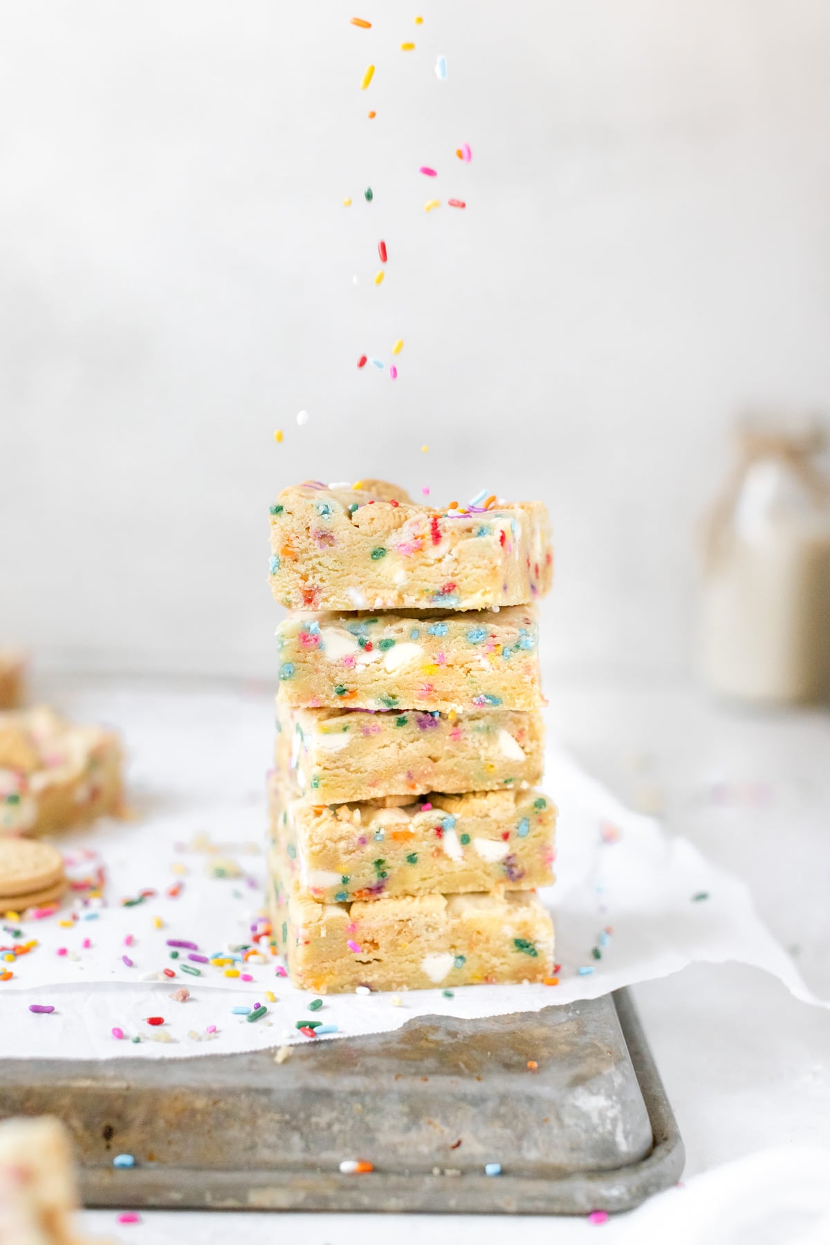 a stack of funfetti cookie bars on parchment paper