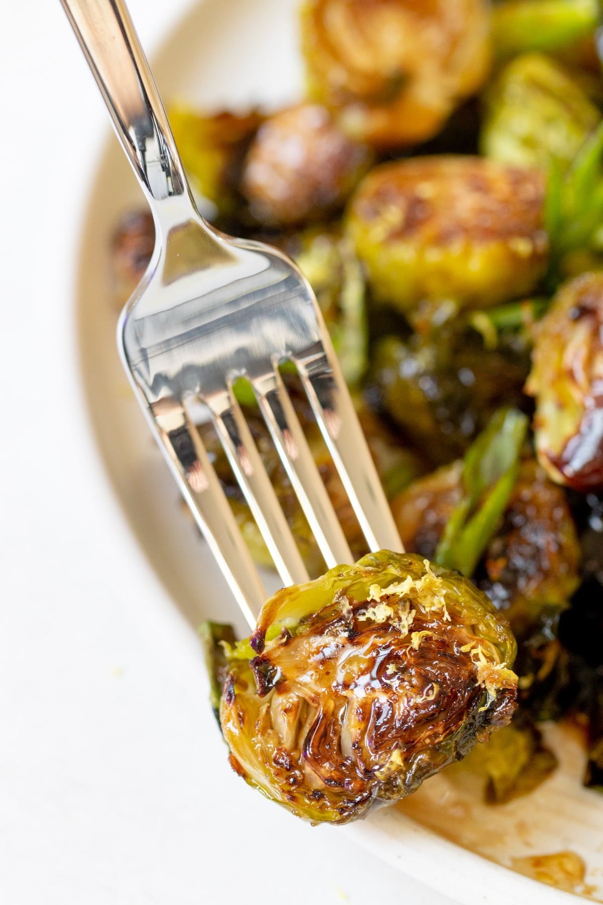 a fork inserted into a roasted brussels sprout