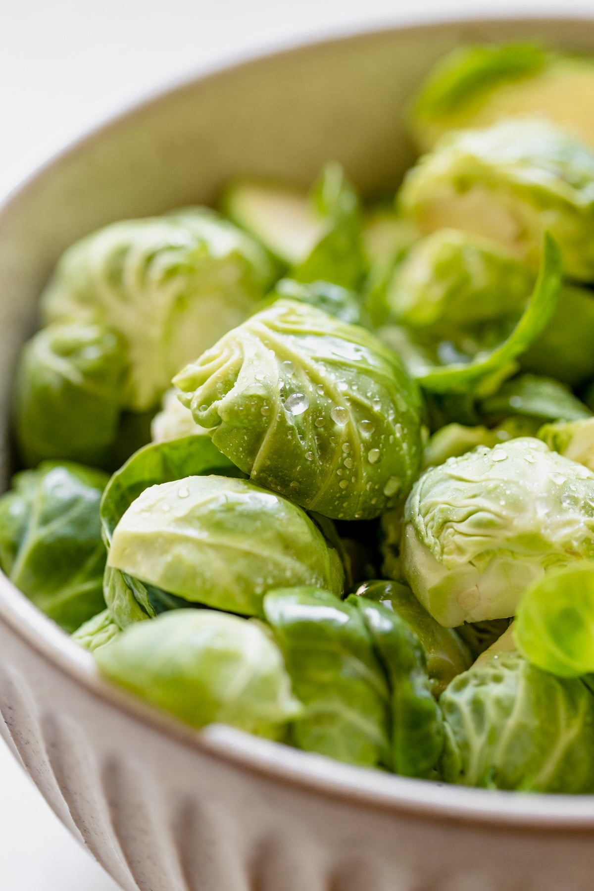 fresh brussels sprouts cut in half in a bowl 