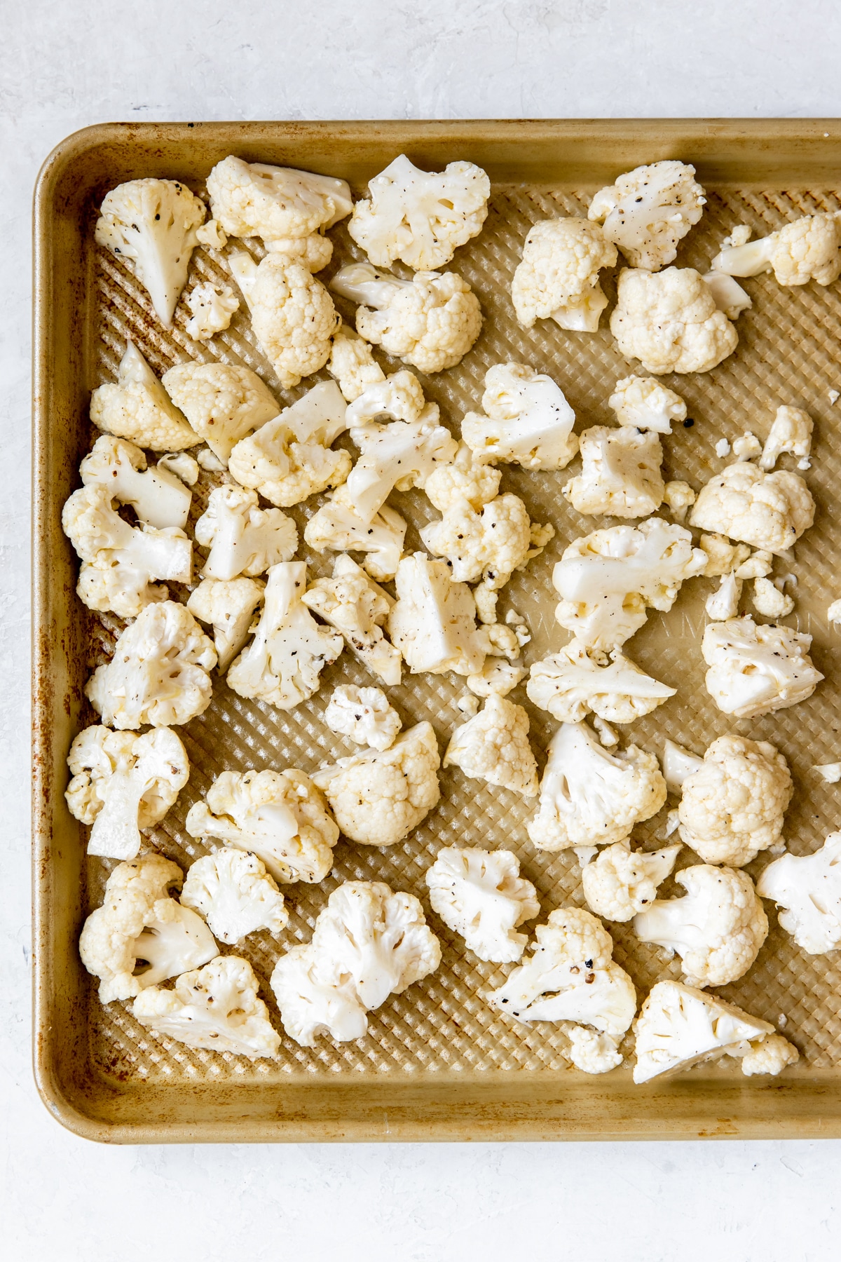 cauliflower florets on a gold baking sheet