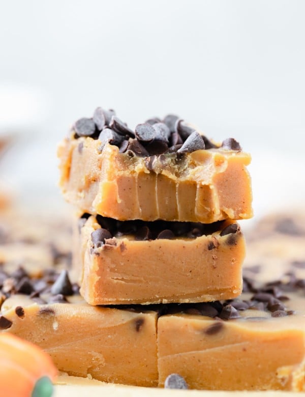 pumpkin fudge bars stacked on top of each other topped with mini chocolate chips