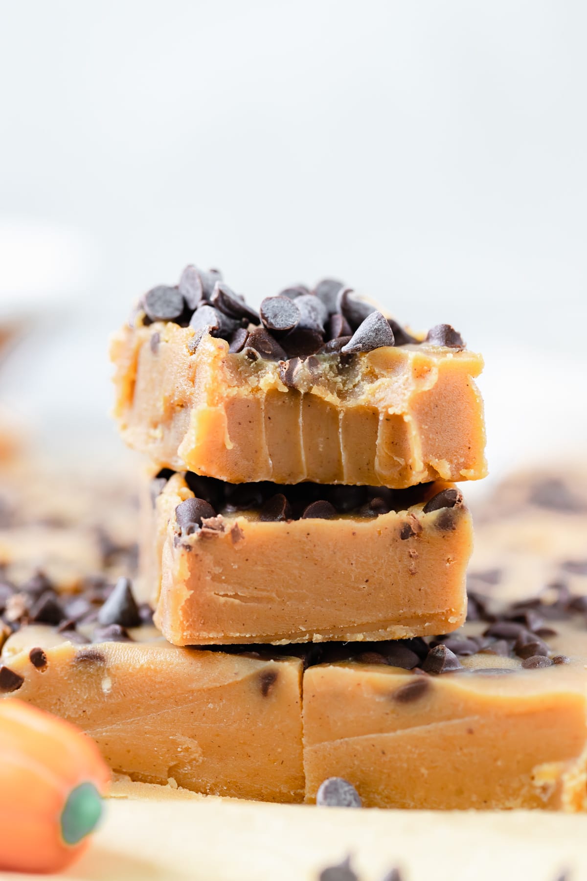 pumpkin fudge bars stacked on top of each other topped with mini chocolate chips