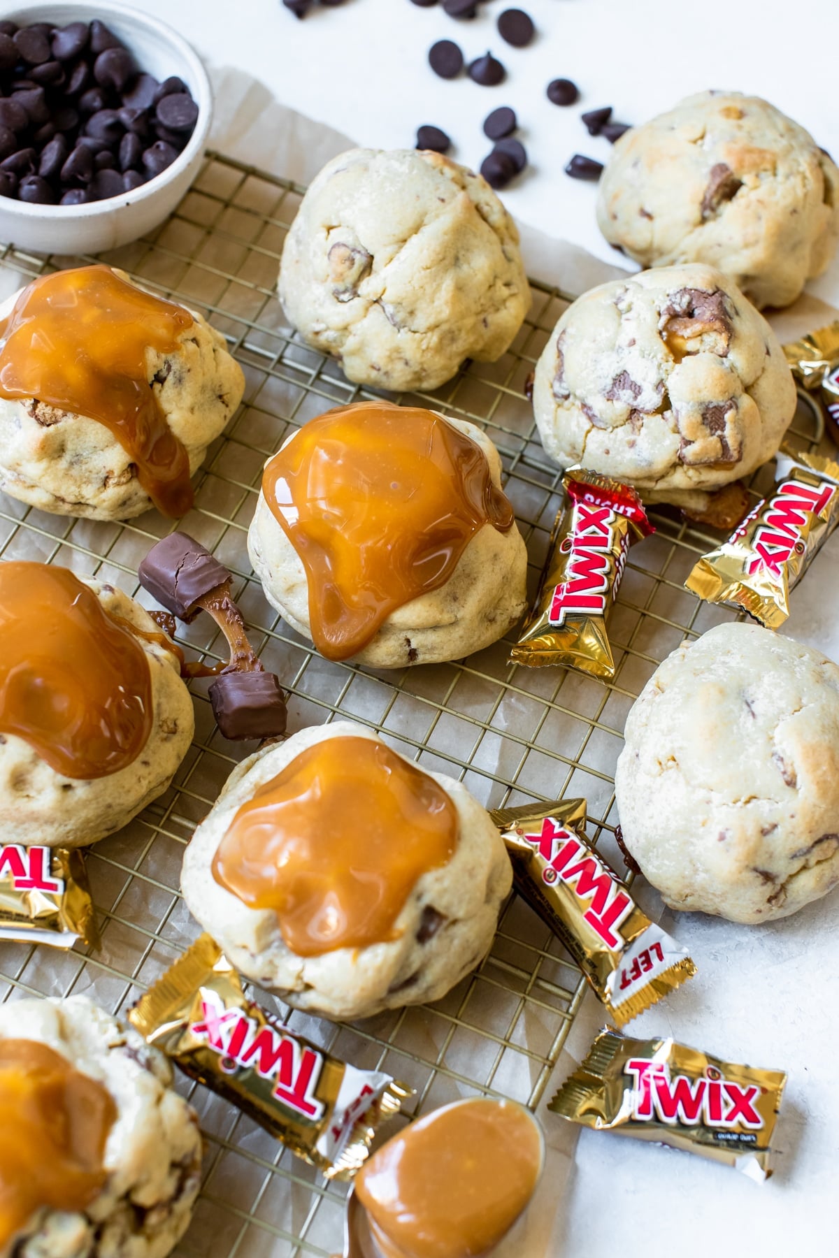 cookies topped with caramel on a gold cooling rack
