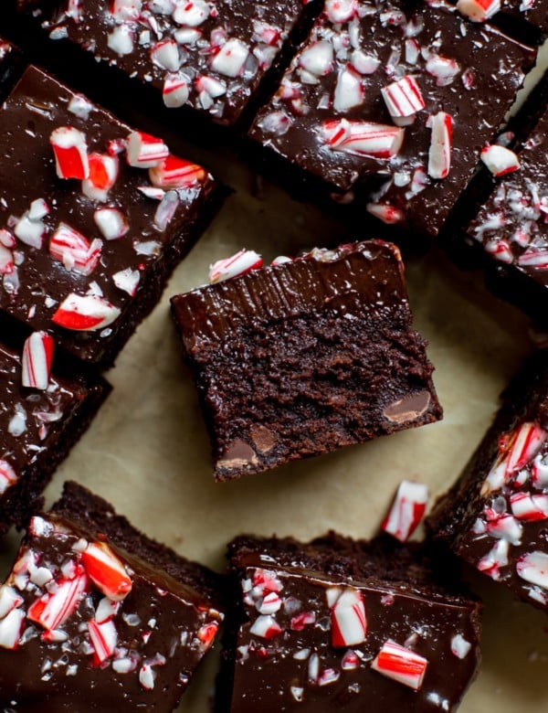 brownies cut into squares topped with chocolate ganache and chopped candy canes