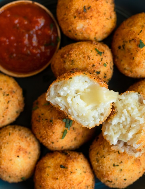 fried rice formed into balls on a blue plate with marinara
