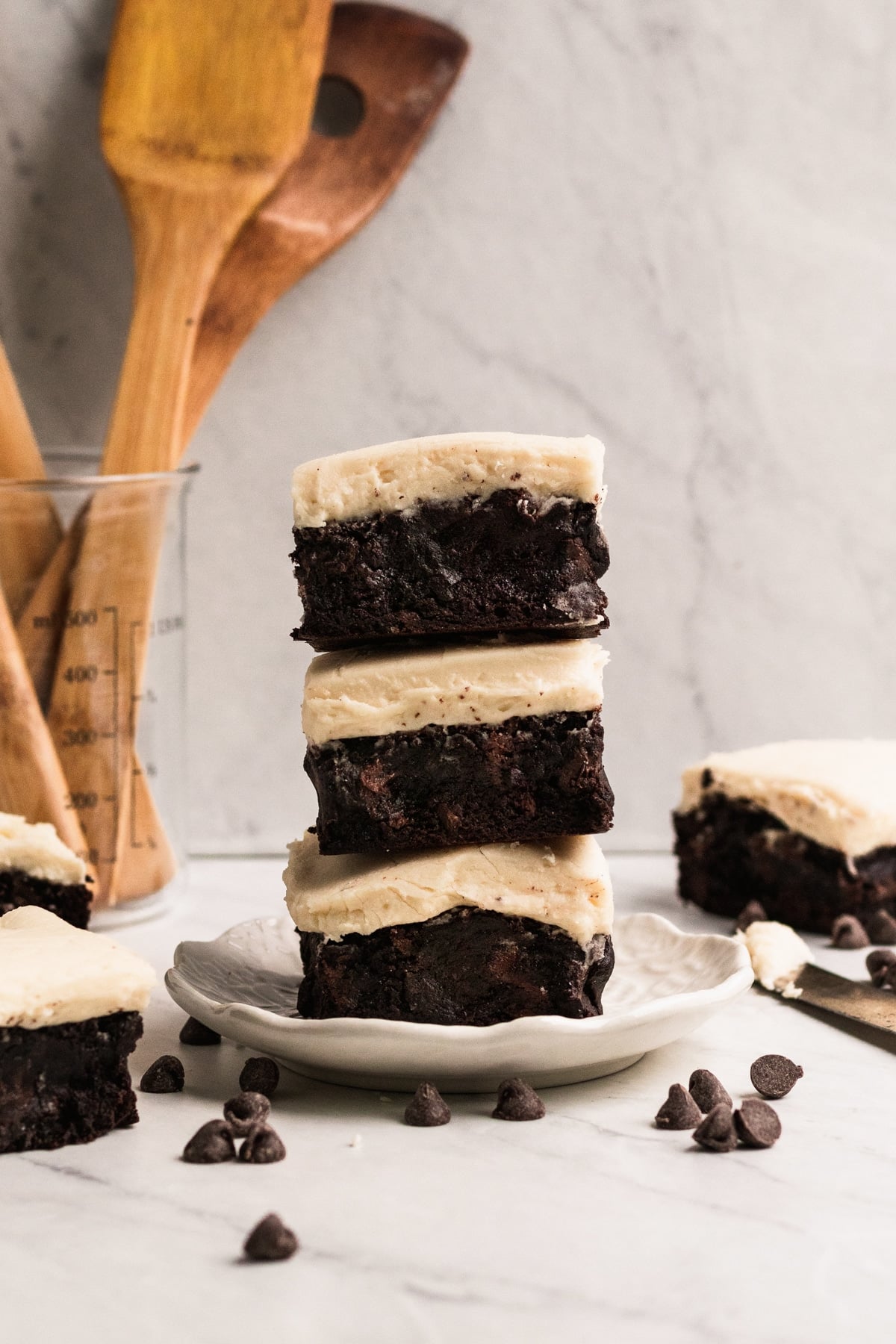 a stack on brownies with frosting on a white plate