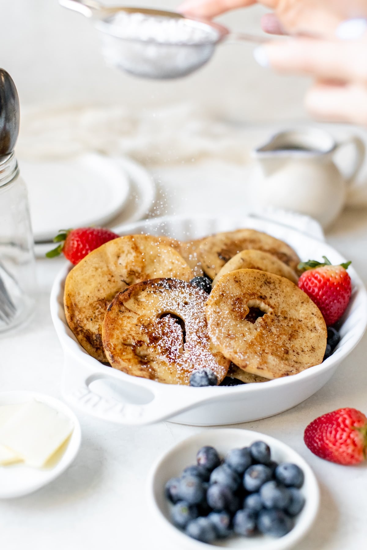 powdered sugar being sprinkled on bagels 