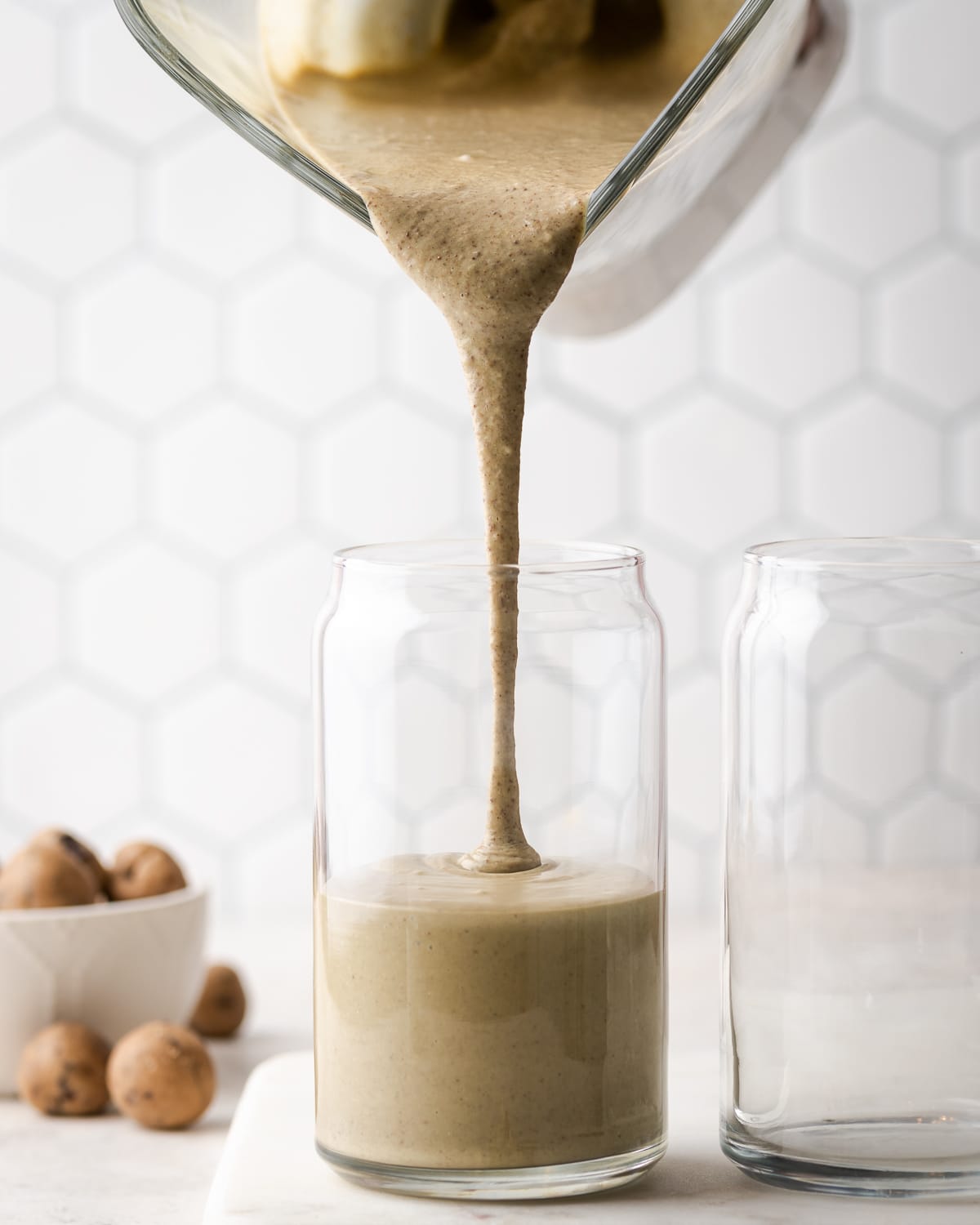 a smoothie being poured into a glass 