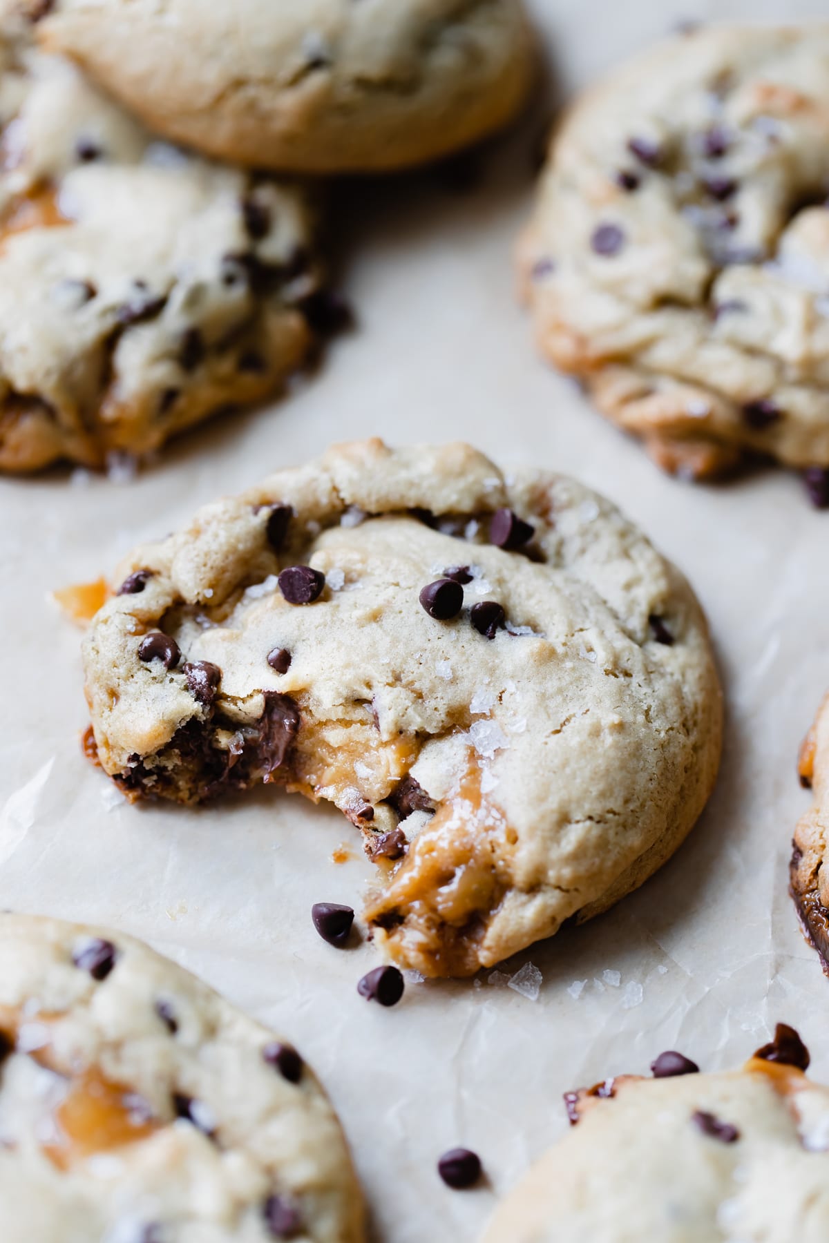 a cookie on parchment paper with a bite taken out of it