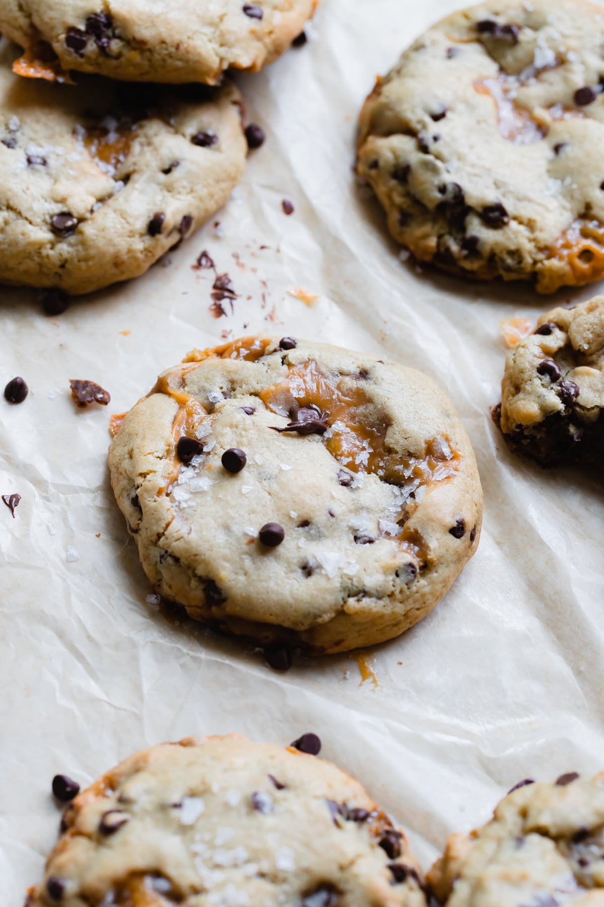 a salted caramel cookie on parchment paper with flaky sea salt on top