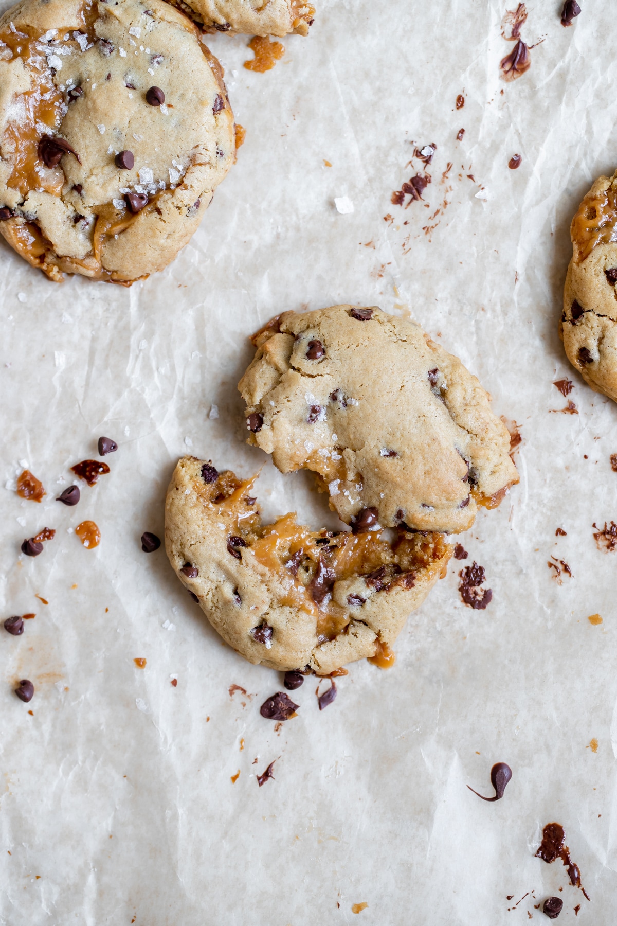 a fresh cookie from the oven pulled apart in half with caramel oozing out