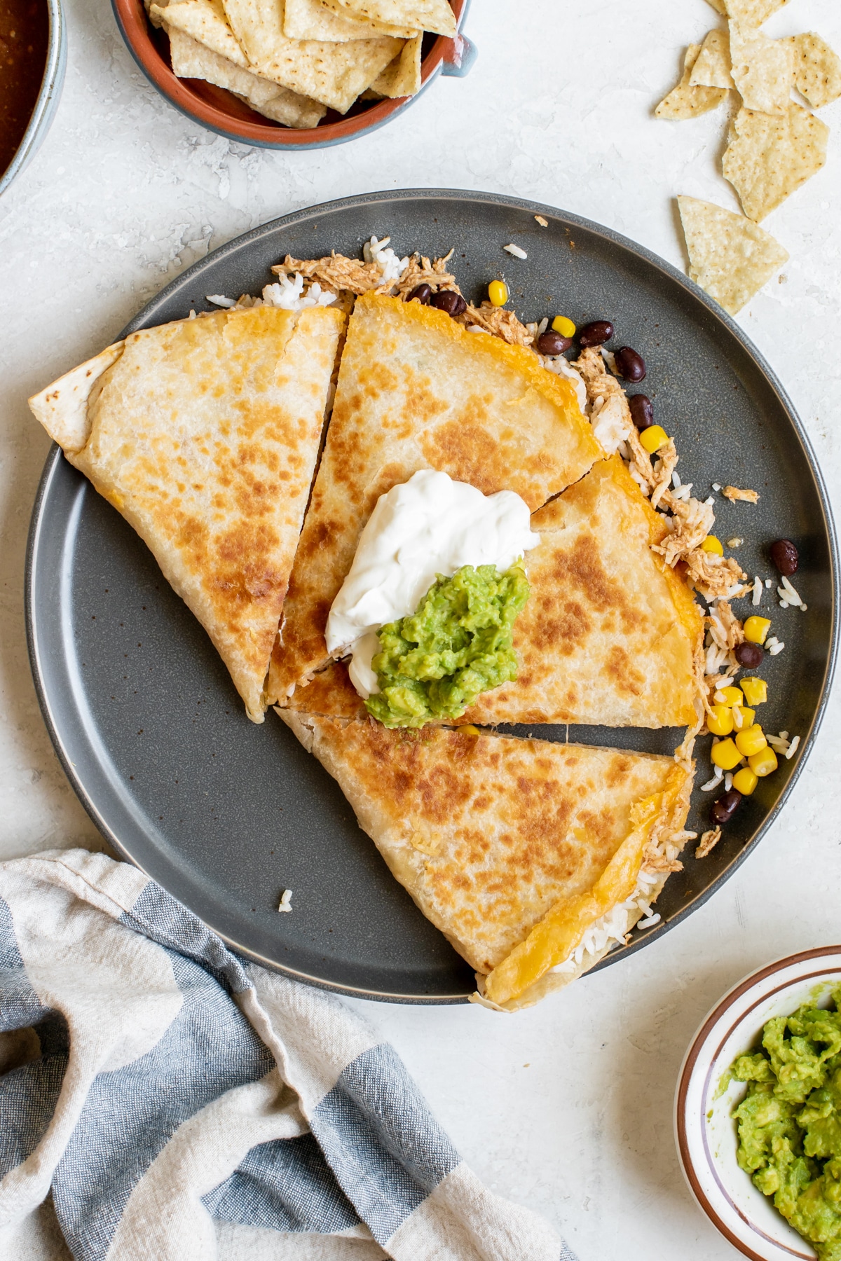 a chipotle chicken quesadilla cut into 4 triangles on a dark blue plate